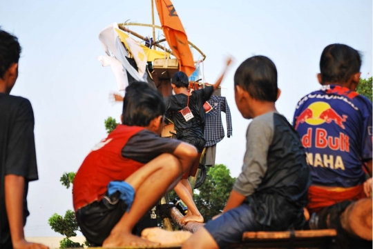 Keseruan lomba panjat pinang di atas aliran Kalimalang