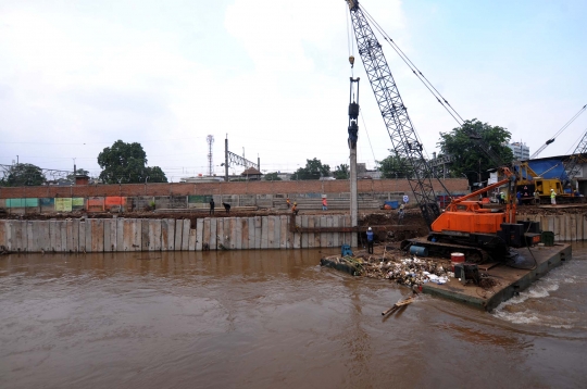 Pemasangan tiang pancang di bantaran Kali Ciliwung