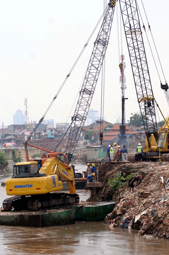 Pemasangan tiang pancang di bantaran Kali Ciliwung