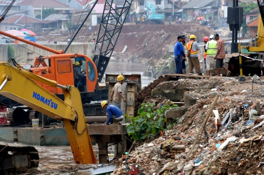 Pemasangan tiang pancang di bantaran Kali Ciliwung