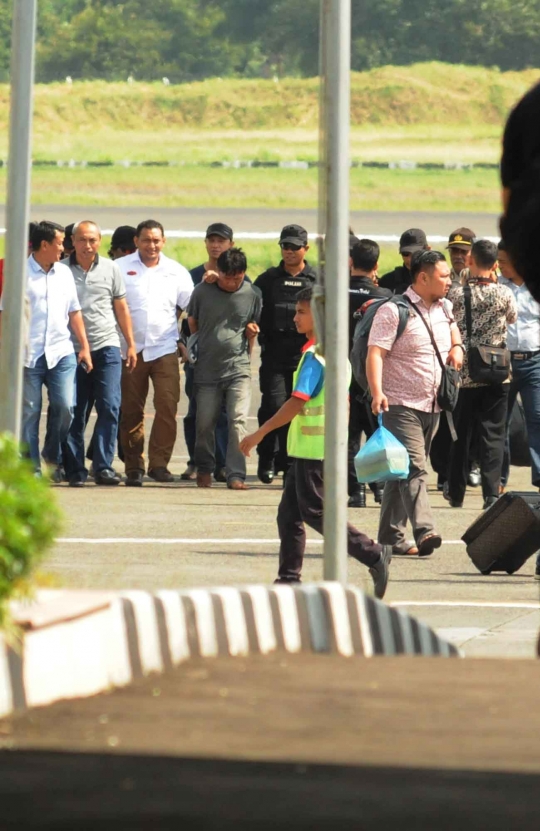 Ekspresi perampok Pulomas Ius Pane saat tiba di Bandara Halim