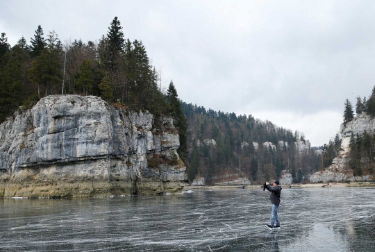 Serunya main es skating di sungai Swiss yang membeku
