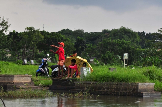 Keseruan anak-anak memancing di tengah kuburan Tanah Kusir