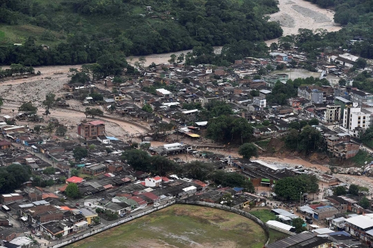 Batang pepohonan bergelimpangan usai banjir bandang menyapu Kolombia