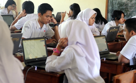 Keseriusan murid SMA mengikuti Ujian Nasional Berbasis Komputer