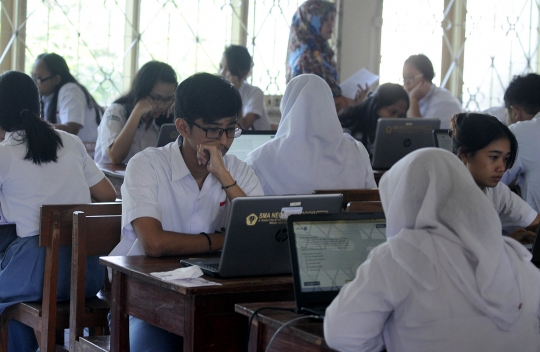 Keseriusan murid SMA mengikuti Ujian Nasional Berbasis Komputer