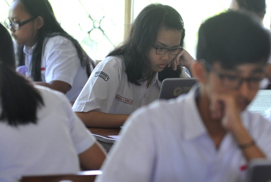 Keseriusan murid SMA mengikuti Ujian Nasional Berbasis Komputer