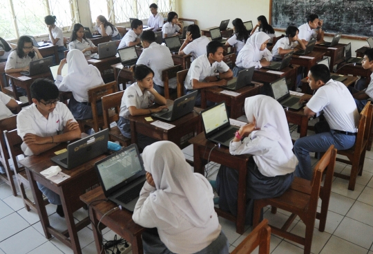 Keseriusan murid SMA mengikuti Ujian Nasional Berbasis Komputer