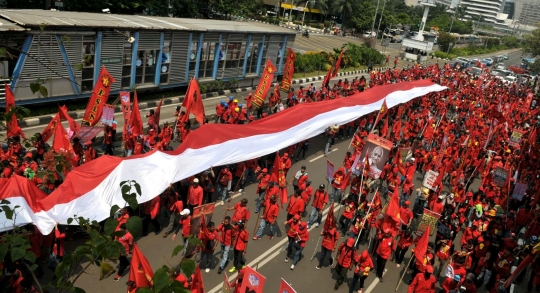 Ribuan buruh arak bendera merah putih raksasa di Jalan Thamrin