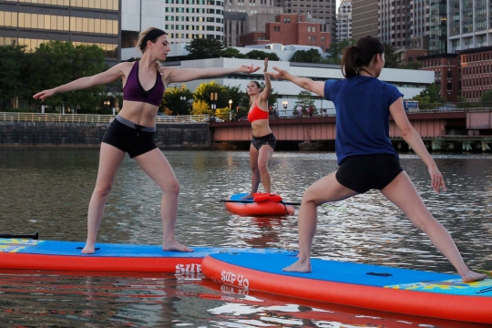 Aksi wanita Amerika Serikat yoga di atas laut