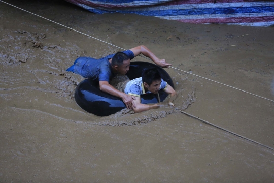 Aksi warga China terjang derasnya banjir bandang dengan ban