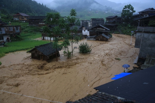 Aksi warga China terjang derasnya banjir bandang dengan ban