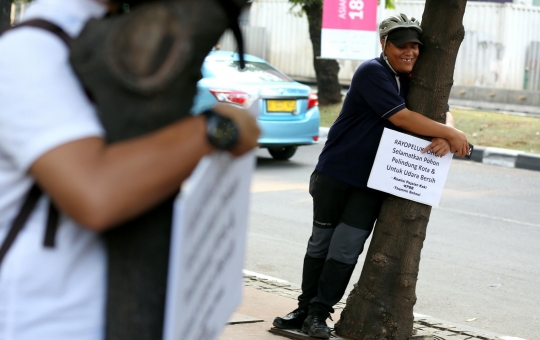 Tolak dipindahkan, pejalan kaki peluk pohon di trotoar Sudirman