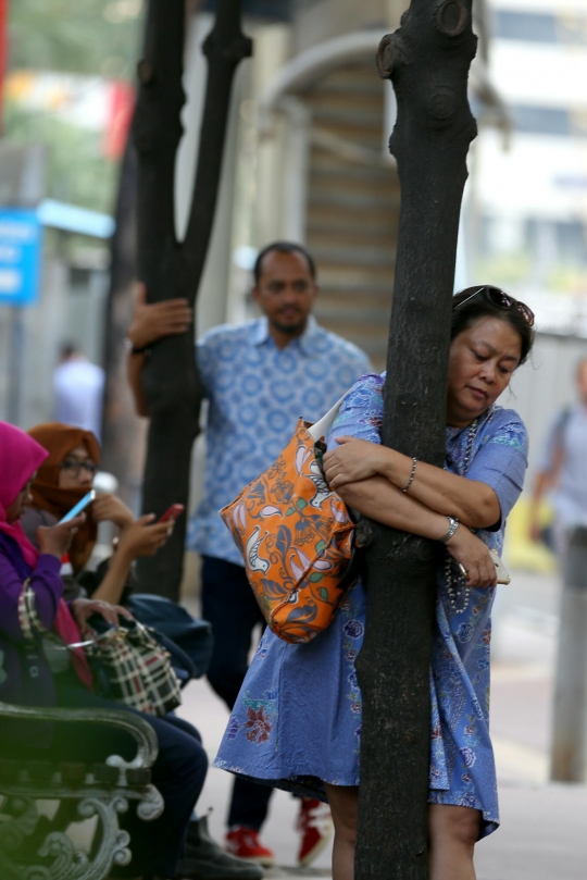 Tolak dipindahkan, pejalan kaki peluk pohon di trotoar Sudirman