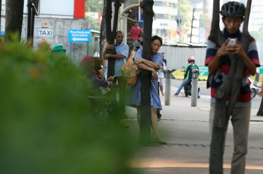 Tolak dipindahkan, pejalan kaki peluk pohon di trotoar Sudirman