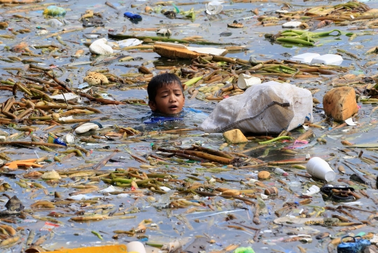 Potret anak-anak mencari botol plastik di tengah kotornya Teluk Manila