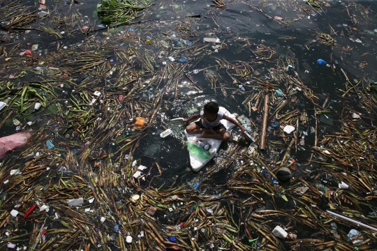 Potret anak-anak mencari botol plastik di tengah kotornya Teluk Manila