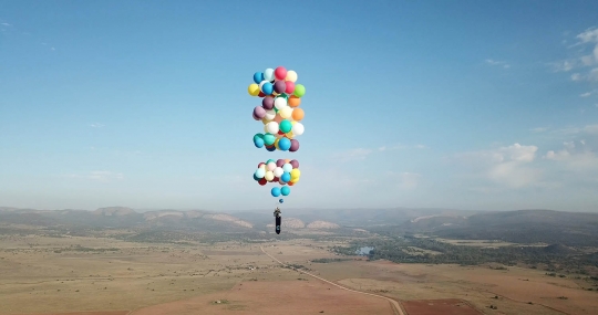 Aksi menegangkan Tom Morgan terbang dengan 100 balon warna-warni bak film kartun