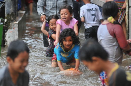 Keceriaan anak-anak bermain di tengah banjir Jati Padang