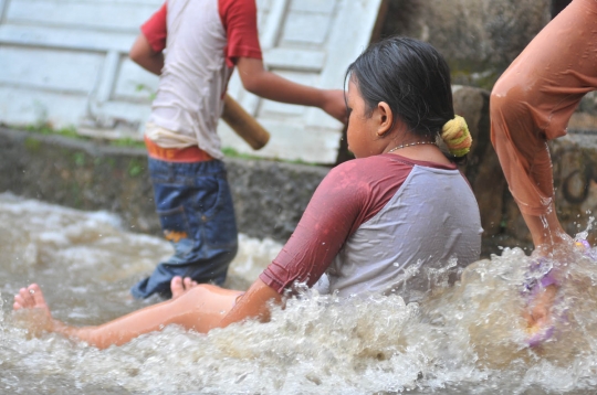 Keceriaan anak-anak bermain di tengah banjir Jati Padang