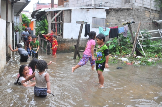 Keceriaan anak-anak bermain di tengah banjir Jati Padang