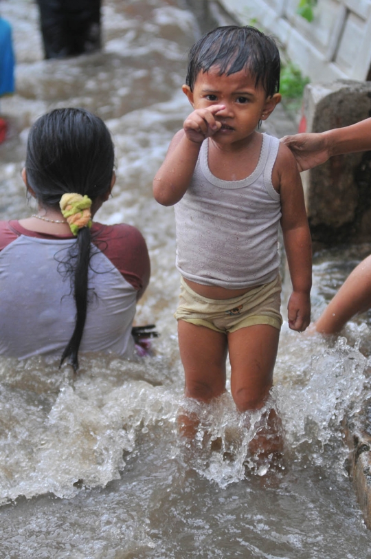 Keceriaan anak-anak bermain di tengah banjir Jati Padang