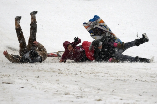 Keasyikan warga AS meluncur hingga terjatuh di tengah badai es