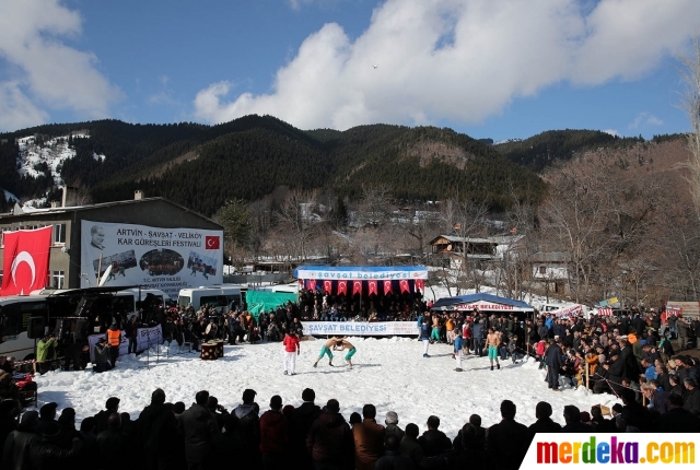 Ribuan orang menyaksikan turnamen gulat di arena berselimut salju di Desa Velikoy, Provinsi Artvin, Turki utara, Sabtu (10/2).