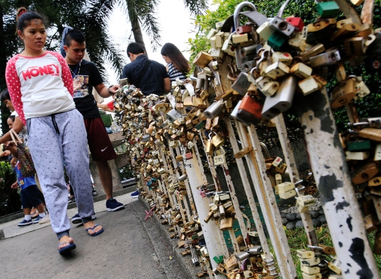 Menggantungkan gembok cinta di kuil Filipina