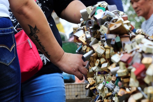 Menggantungkan gembok cinta di kuil Filipina