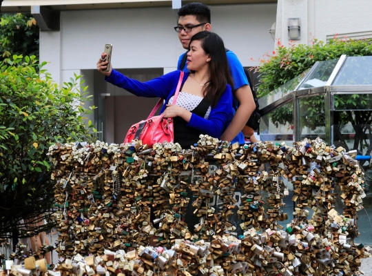 Menggantungkan gembok cinta di kuil Filipina