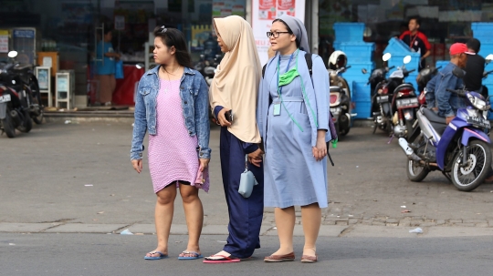 Potret keharmonisan wanita berkerudung bantu biarawati menyeberang jalan