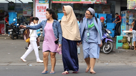 Potret keharmonisan wanita berkerudung bantu biarawati menyeberang jalan