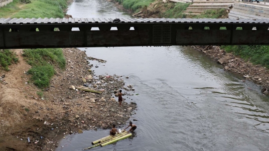 Potret anak-anak main rakit di Sungai Ciliwung tanpa alat keselamatan