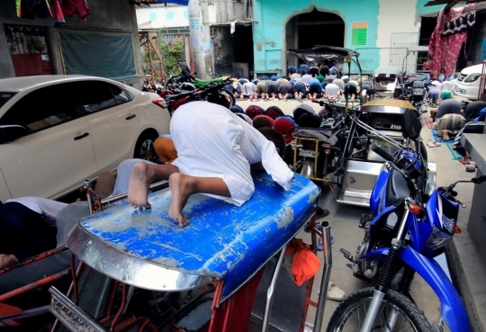 Tak dapat ruang, bocah ini khusyuk meski salat Jumat di atap bentor