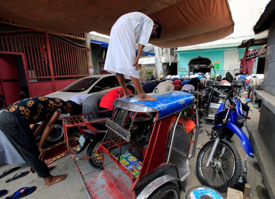 Tak dapat ruang, bocah ini khusyuk meski salat Jumat di atap bentor