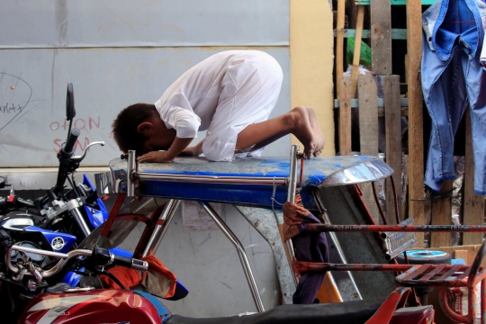 Tak dapat ruang, bocah ini khusyuk meski salat Jumat di atap bentor