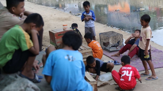 Tunggu waktu buka puasa, anak-anak bermain di bantaran Ciliwung