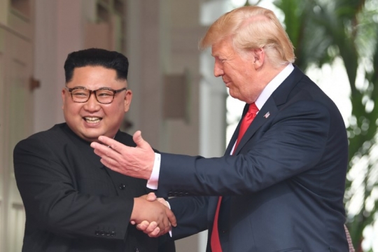Senyum semringah Kim Jong-un saat jabat tangan Trump