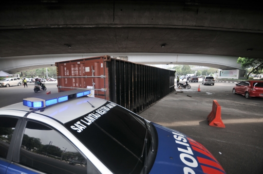 Kelebihan muatan, truk kontainer terguling di kolong flyover Tomang