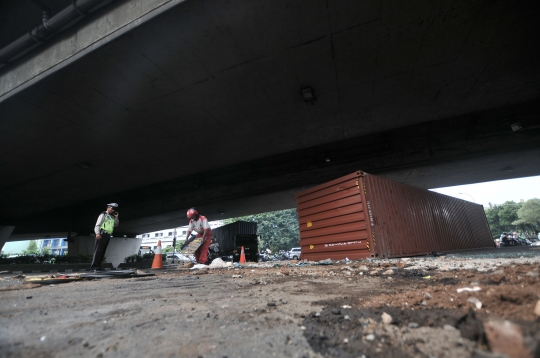 Kelebihan muatan, truk kontainer terguling di kolong flyover Tomang