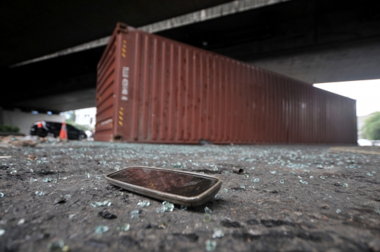 Kelebihan muatan, truk kontainer terguling di kolong flyover Tomang