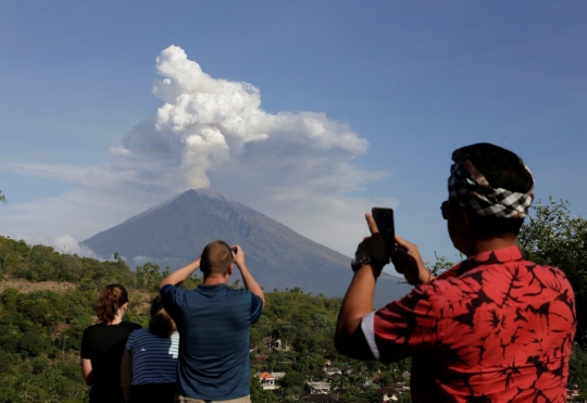 Keasyikan turis potret muntahan abu vulkanik Gunung Agung