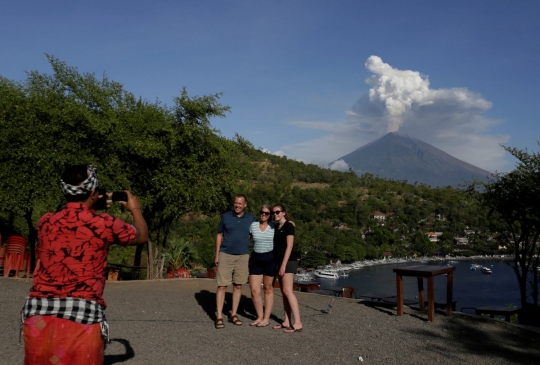 Keasyikan turis potret muntahan abu vulkanik Gunung Agung