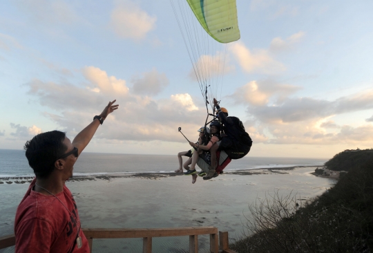 Keseruan wisatawan terbang tandem paralayang di Nusa Dua