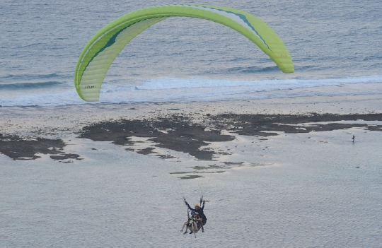 Keseruan wisatawan terbang tandem paralayang di Nusa Dua