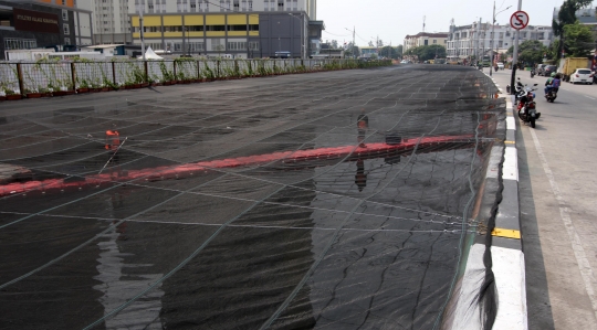 Kali dekat Wisma Atlet Kemayoran ditutup kain hitam untuk kurangi bau