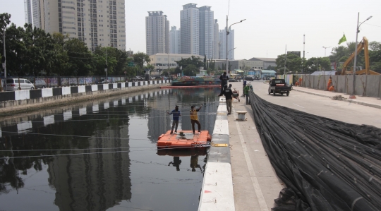 Kali dekat Wisma Atlet Kemayoran ditutup kain hitam untuk kurangi bau