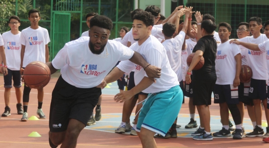 Aksi pemain NBA Jaylen Brown main basket dengan anak-anak