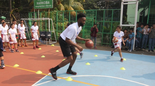 Aksi pemain NBA Jaylen Brown main basket dengan anak-anak